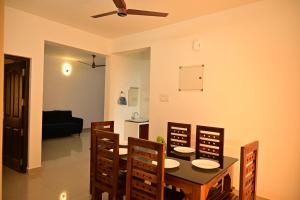 a dining room with a table and chairs and a couch at Geetham Villas in Palakkad