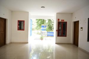 a hallway with white walls and a hallway with two doors at Geetham Villas in Palakkad
