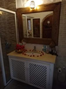 a bathroom with a sink and a mirror at Riad Dar El Caid - Palais XIII Siecle in Tozeur