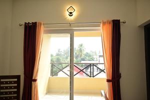 ventana con vistas a un balcón en Geetham Villas en Palakkad