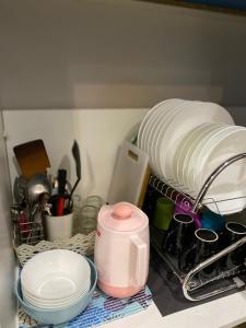 a dish drying rack with plates and dishes in a kitchen at Homestay Yana - Bangi Avenue near Bangi Wonderland in Kajang