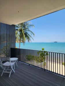 balcón con mesa y vistas al océano en Beachfront 3 Bedrooms - AMANA Villa at Ta-Ke Residence Phuket, en Phuket