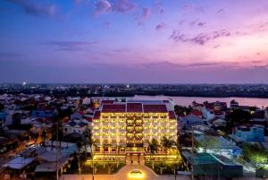 a large building with lights in a city at night at Wyndham Garden Hoi An Cua Dai Beach in Hoi An
