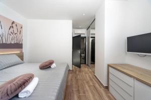 a bedroom with a bed and a flat screen tv at Royal House 3 in Pašman