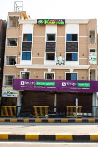 un bâtiment avec un panneau violet devant lui dans l'établissement Hotel Kiwi Inn, à Indore