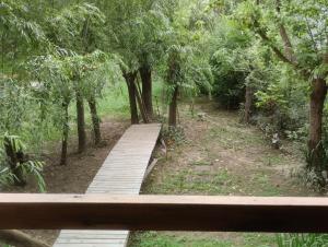 un puente de madera en un bosque con árboles en Cabaña Isla Coco en Tigre