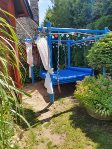 un banc bleu dans une cour avec des plantes dans l'établissement Zagroda, à Sarbinowo