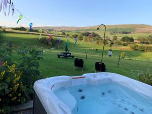 una bañera de hidromasaje en un patio con un campo en 1 Bed in Eden Valley 82493, en Kirkoswald