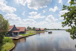 a view of a lake with houses and a boat at Dormio Waterpark Langelille in Langelille +11 photos