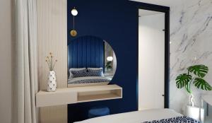 een slaapkamer met een spiegel aan een blauwe muur bij Apartament LUNA z jacuzzi Premium na Mazurach in Ełk