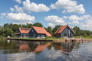 two houses on the shore of a body of water at Dormio Waterpark Langelille in Langelille