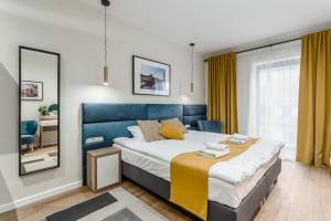 a bedroom with a large bed and a mirror at Deo Plaza Apartamenty Premium in Gdańsk