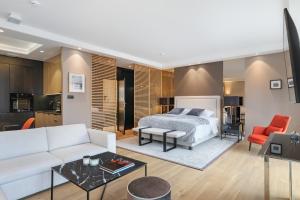 a bedroom with a bed and a living room at Deo Plaza Apartamenty Premium in Gdańsk