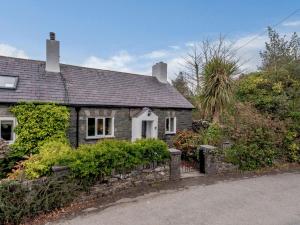 a small stone house with a stone wall at 1 Bed in Bethesda 82577 in Llanddeiniolen