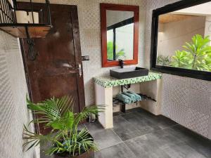 La salle de bains est pourvue d'un lavabo et d'un miroir. dans l'établissement Tiny Villa Votre Villa Privatisée, à Ndangane
