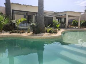 a house with a swimming pool in front of a house at Tiny Villa Votre Villa Privatisée in Ndangane