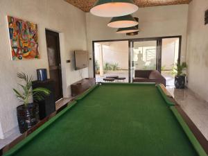 un salon avec une grande table de billard vert dans l'établissement Tiny Villa Votre Villa Privatisée, à Ndangane