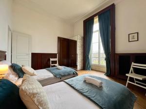 een slaapkamer met 2 bedden en een groot raam bij Une nuit royale / Proche Forêt in Veneux-les-Sablons