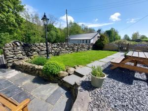 a garden with a stone wall and a picnic table at 3 Bed in Spark Bridge 83701 in Spark Bridge
