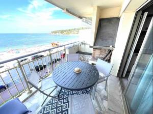 a balcony with a table and chairs and the beach at Cap d'Antibes Studio et terrasse face à la mer in Antibes +22 photos