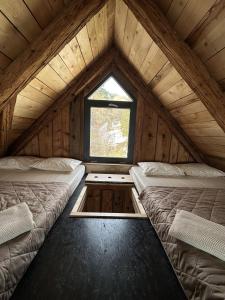 a room with two beds and a window in a cabin at Humno in Nová Baňa