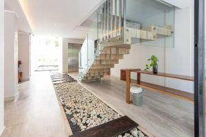 a living room with a staircase and a pebble floor at Toh House Luxury by Boutique Apartments MX in Playa del Carmen