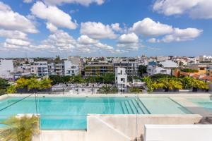 a large swimming pool with a city in the background at Toh House Luxury by Boutique Apartments MX in Playa del Carmen