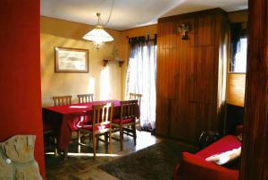 a dining room with a red table and chairs at Lo Scoiattol House in Limone Piemonte
