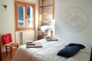 a bedroom with a bed with towels on top of it at Lo Scoiattol House in Limone Piemonte