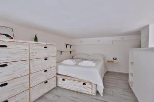 a white bedroom with a bed and a dresser at [Porta Genova] Navigli country house in Milan