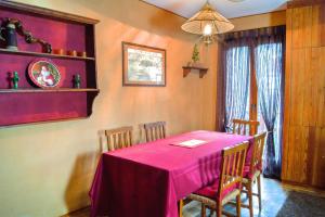 a dining room with a pink table and chairs at Lo Scoiattol House in Limone Piemonte