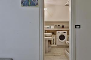 a bathroom with a sink and a washing machine at [Porta Genova] Navigli country house in Milan