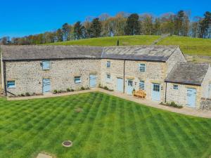 an aerial view of a stone house with a large yard at Grange Barn, Ashford In The Water in Great Longstone