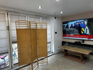 d'un salon avec trois chaises en osier et une télévision à écran plat. dans l'établissement Stunning 1-Bed Studio in London, à Londres