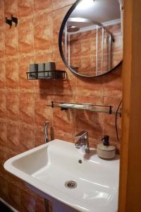 La salle de bains est pourvue d'un lavabo et d'un miroir. dans l'établissement Na Penkah, à Yaremtche