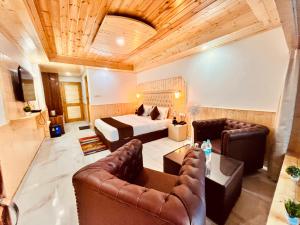 マナリにあるHimalayan Village Resort, Manaliのベッドとソファのあるホテルの部屋