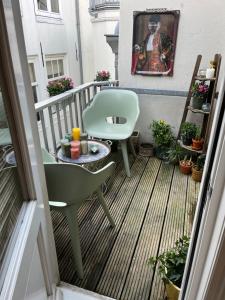 Attic Monkeys Lodge في أمستردام: شرفة مع كرسي أخضر وطاولة
