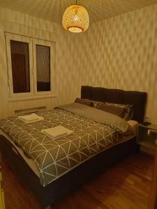 Una cama en un dormitorio con una lámpara de araña. en Srebrni Breg, en Zlatibor