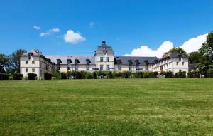 een groot grasveld voor een groot gebouw bij Kergonano - Parking privé et piscine in Baden