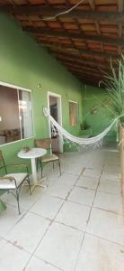 a room with a hammock and a green wall at Casa Astral Buzios in Búzios