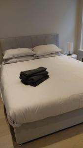 a white bed with a black robe on it at Soho super apartment in London