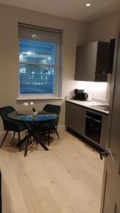 a kitchen with a table and chairs and a window at Soho super apartment in London