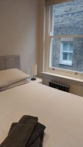 a bedroom with a white bed with a window at Soho super apartment in London
