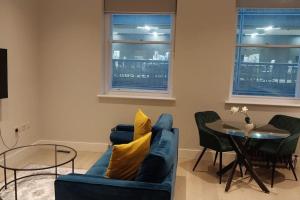 a living room with a blue couch and a table at Soho super apartment in London