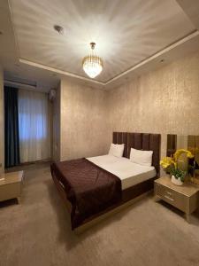 a bedroom with a large bed and a chandelier at The Mirror Hotel in Baku