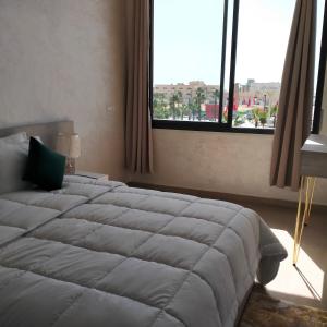 a bedroom with a large bed and a large window at Palm D'or-Appartement familial de luxe au centre de Dakhla in Dakhla