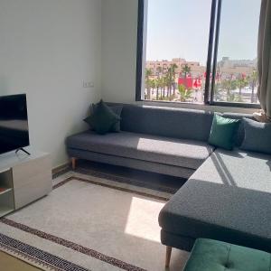 a living room with a couch and a tv at Palm D'or-Appartement familial de luxe au centre de Dakhla in Dakhla