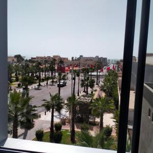 uma vista de uma janela de um parque de estacionamento com palmeiras em Palm D'or-Appartement familial de luxe au centre de Dakhla em Dakhla