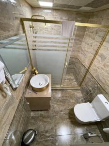 a bathroom with a toilet and a sink and a shower at The Mirror Hotel in Baku