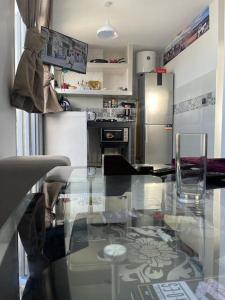 a kitchen with a glass table and a refrigerator at Appartement- Terrasse sublime in El Jadida